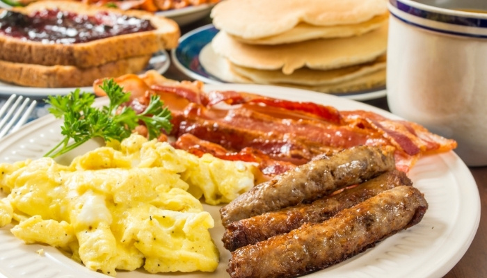 Plate with scrambled eggs, sausage, bacon, and pancakes at Fifth Avenue Taphouse New Brighton.