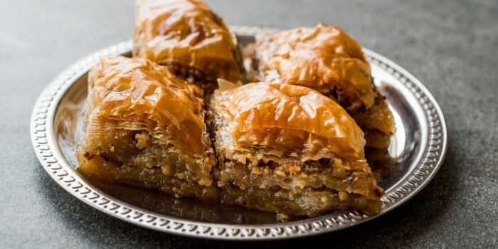 Four pieces of baklava on a silver plate at Fifth Avenue Taphouse New Brighton, nutty and flaky.