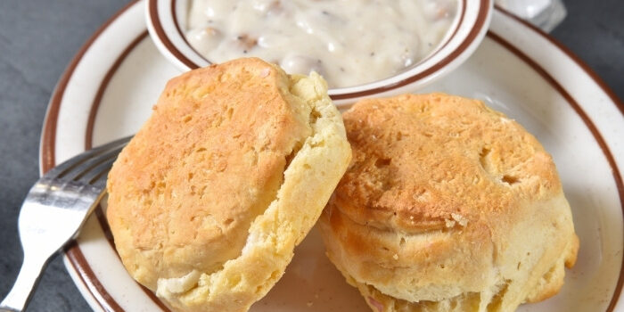 Two biscuits on a plate at Fifth Avenue Taphouse New Brighton with gravy in the background.