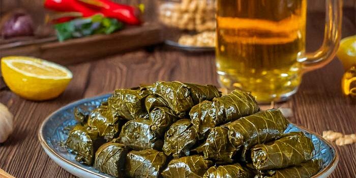A plate of stuffed grape leaves at Fifth Avenue Taphouse New Brighton with beer and garnishes.